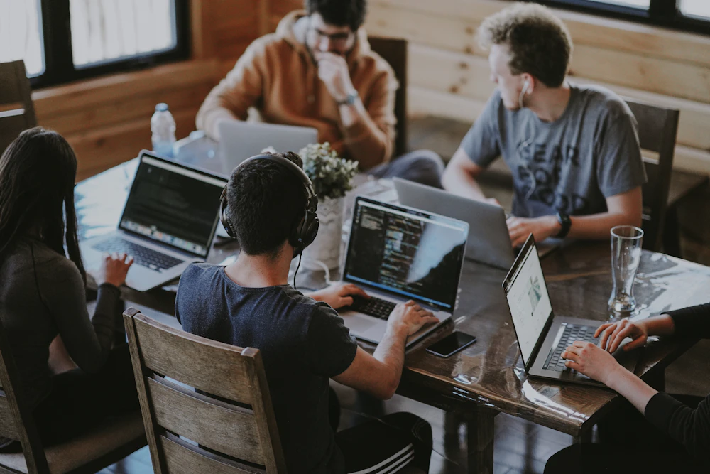 People working together with laptops around a shared table